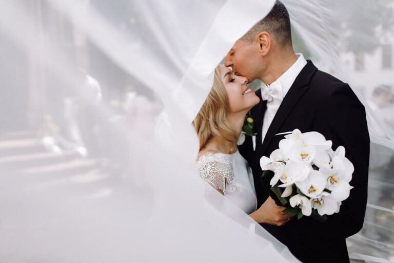 optimize-groom-black-tuxedo-hugs-tender-stunning-bride-while-they-stand.jpg